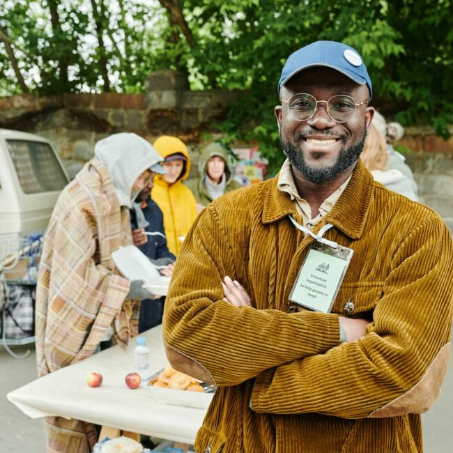 Volunteer helping homeless people outdoors